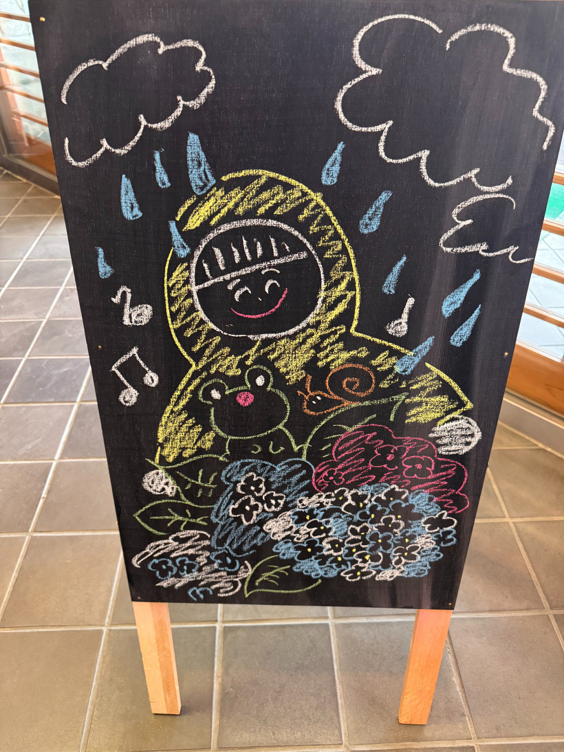 カッパを着た子供とカエルと雨の絵